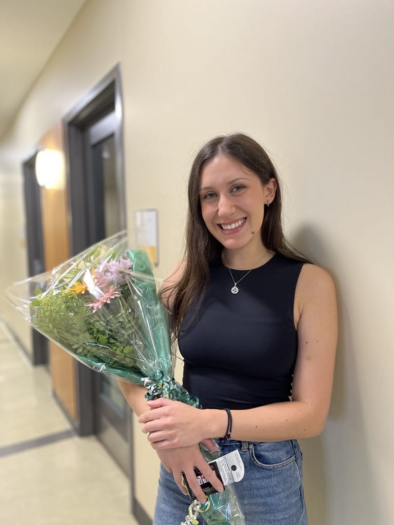 Alyssa holding flowers to celebrate her successful MSc defense 